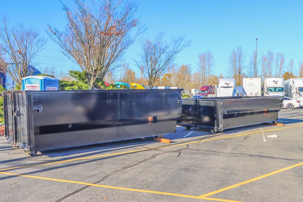 Professional dumpster rental service with roll-off container on residential driveway in Fort Shawnee
